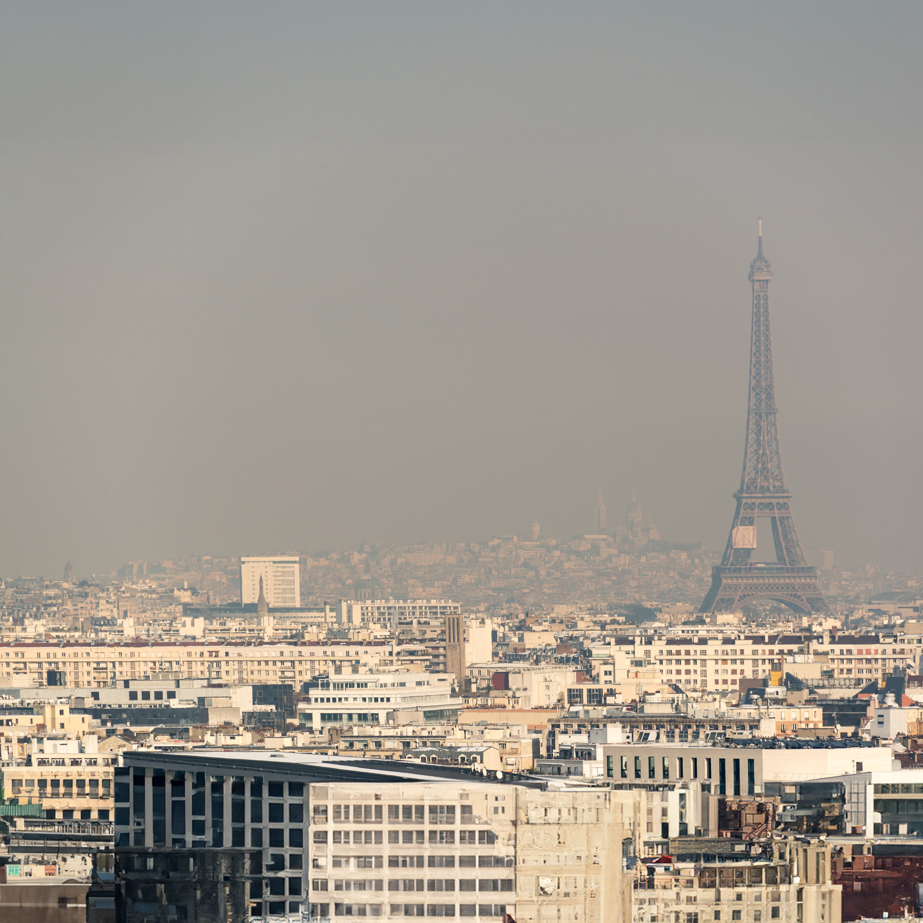 Striking view of environmental pollution in Paris with the Eiffel Tower in the background, highlighting the need for protection against external aggressions.